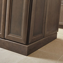 close up image of baseboard moulding on gray-brown cabinets