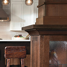 craftsman-style kitchen with white inset cabinets and deep brown stained decorative cabinets featuring creative moulding accents
