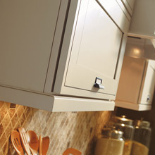 light color painted rail moulding mounted to bottom of wall cabinets
