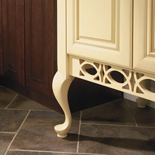 Close up of Queen Anne cabinet leg on light yellow cabinets